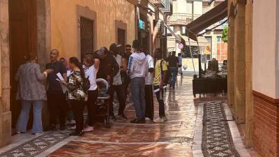 Migrantes hacen cola para sacar cita previa para su regularización, a 16 de abril.