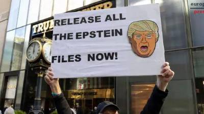 Un manifestante con un cartel en el que pone: Publicad todos los archivos de Epstein ya con la cara del presidente de EEUU, Donald Trump, en la Torre Trump de la Quinta Avenida (EEUU). / Europa Press.