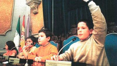 Un niño levantaba la mano para pedir la palabra durante el pleno que celebraron en el Ayuntamiento de Jaén. / Archivo Histórico de Diario JAÉN.