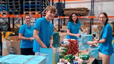 Varios voluntarios de Fundación La Caixa ordenan productos en el Banco de Alimentos de Jaén.