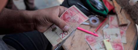 Un palestino arregla un billete desgastado, en el sur de la Franja de Gaza. / Rizek Abdeljawad / Europa Press.