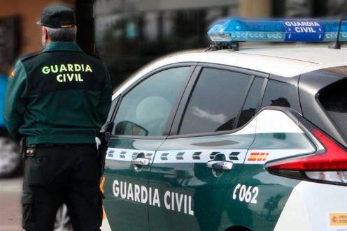 <i>Un agente de la Guardia Civil, de espaldas, junto a un vehículo oficial. Archivo.</i>