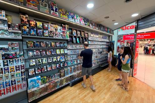 <i>Consumidores de videojuegos en formato físico echan un vistazo en la estantería de PlayStation en el Game Shop de Linares. / Francisco J. Marín / Diario JAÉN</i>