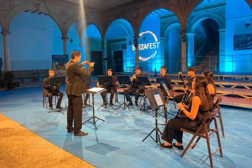 <i>Los vientos de la Orquesta de la Universidad de Jaén interpretan su programa rodeados de la belleza patrimonial de la Antigua Universidad de Baeza. / Ana Lechuga.</i>