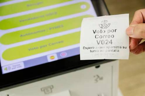 <i>Un ticket de turno de voto por correo en la oficina de Correos. Archivo. / Europa Press.</i>