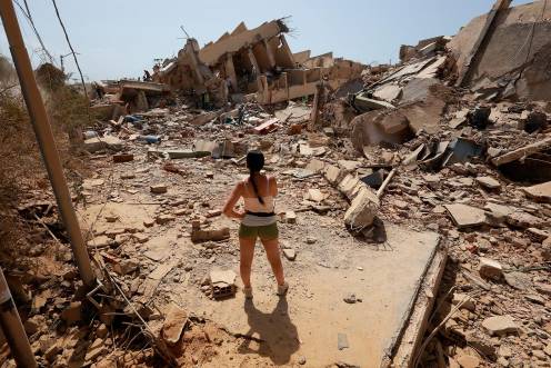 <i>Una mujer frente a varias casas derruidas por los terremotos. / Javier Campos / DPA.</i>