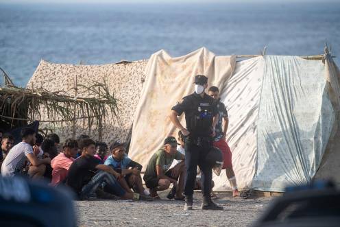 <i>Decenas de migrantes en la playa de El Trampolín, en los primeros días de septiembre, en Ceuta. / Europa Press. </i>
