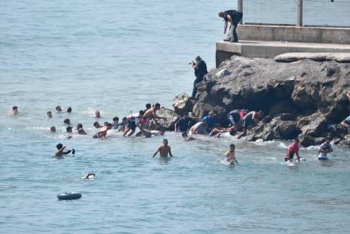 <i>Varias personas intentan cruzar la frontera a nado. / Europa Press. </i>