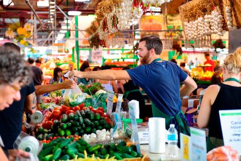 <i>Imagen de archivo de un vendedor atendiendo a un grupo de personas en un mercado. / Junta de Andalucía. </i>