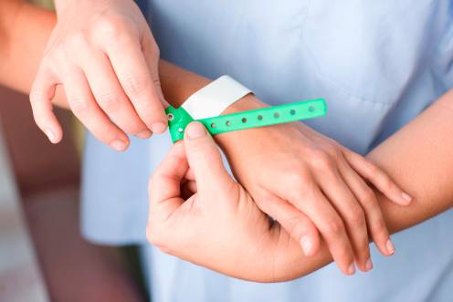 <i>Profesionales ponen la pulsera para identificar al paciente. / Junta de Andalucía.</i>