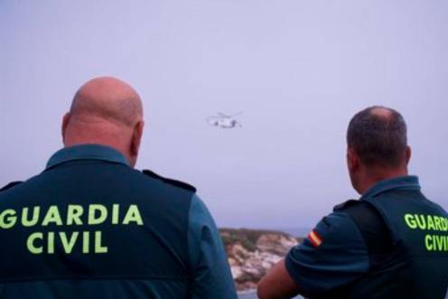 <i>Dos agentes de la Guardia Civil observan a un helicóptero. Archivo. / Gustavo de la Paz / Europa Press.</i>