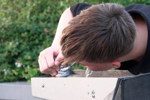 <i>Chico bebiendo agua en una fuente. / Europa Press. </i>