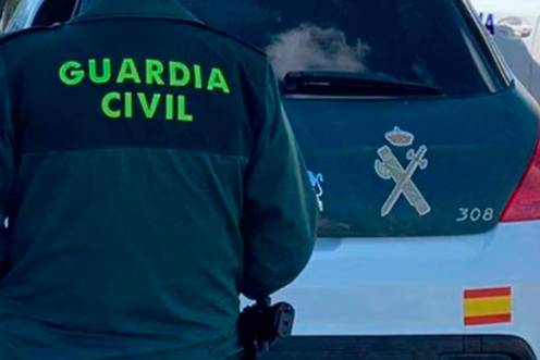 <i>Un agente de la Guardia Civil junto a un vehículo oficial. / Guardia Civil. </i>