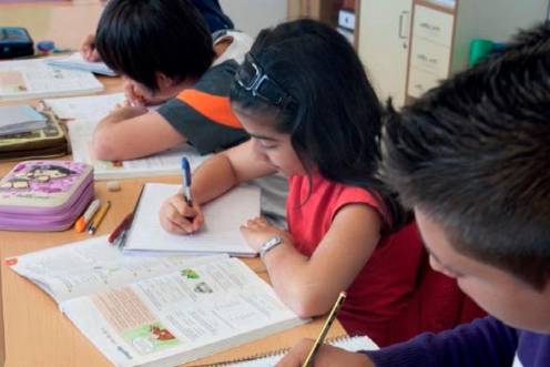 <i>Niños en el colegio con sus libros de texto. / Junta de Andalucía. </i>