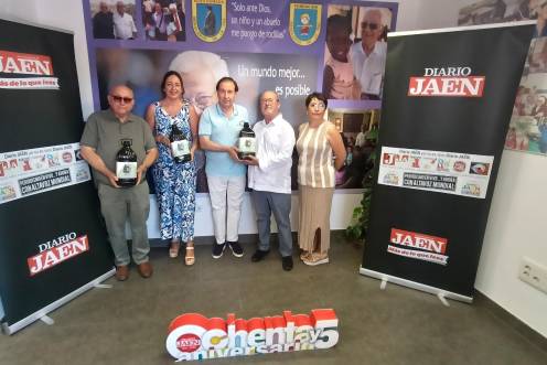 <i>Domingo Bonillo, Ana María Gómez, Matías López, Julio Millán y Paqui Fuentes sostienen varias garrafas de aceite de la empresa Aires de Jaén, en la entrada de la sede de Edad Dorada Mensajeros de la Paz Andalucía en Jaén. / F. Gaitán / Diario JAÉN.</i>