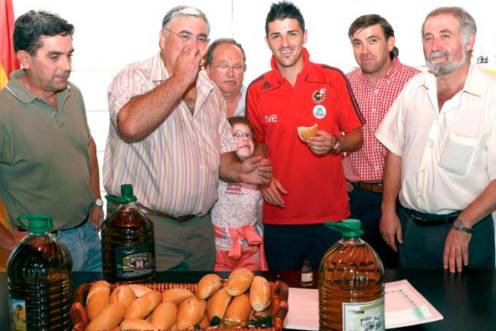 <i>David Villa con un bollo de pan con aceite que le entrega el alcalde de Villatorres. / Archivo histórico Diario JAÉN. </i>