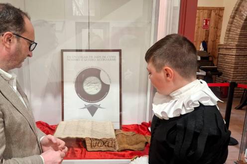 <i>José Ayala y un alumno del Colegio San Vicente de Paúl, junto a la escritura notarial firmada por Cervantes. / Junta de Andalucía.</i>
