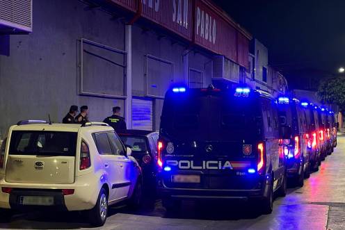 <i>Furgones de la Policía Nacional preparados por si fuesen necesarios durante el traslado de migrantes. / Europa Press. </i>