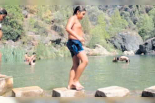 <i>Dos niños juegan en la orilla de la zona recreativa de El Charco de la Pringue, en Villanueva del Arzobispo. / Archivo histórico Diario JAÉN. </i>