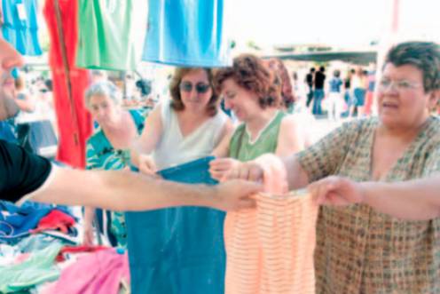 <i>Señoras en un puesto del mercadillo comprando prendas de ropa. / Archivo histórico Diario JAÉN. </i>