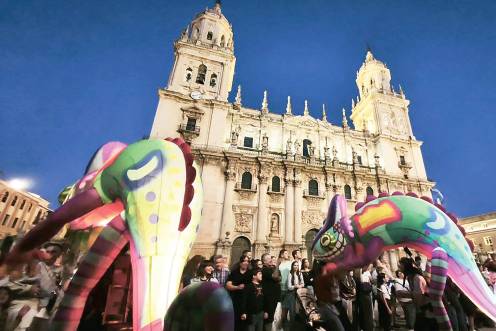 <i>Dos lagartos coloridos pasean con la Catedral de fondo en una Plaza de Santa María a rebosar de personas durante los primeros compases de la cabalgata inaugural de la Feria de San Lucas 2026. / Fotografías: F. Gaitán / Diario JAÉN.</i>