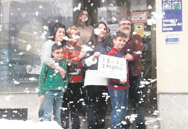 2018. <i>El dueño del estanco marteño, Mariano Castro, celebra con una empleada y su familia el premio en aquella mañana fría y con nieve del 6 de enero. </i>