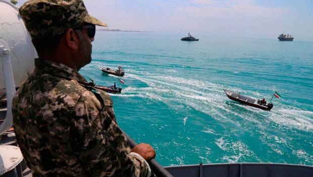 <i>Un miembro de la Guardia Revolucionaria Islámica observa varias lanchas iraníes de la milicia paramilitar Basij a su paso por el Golfo Pérsico / Archivo / Europa Press.</i>