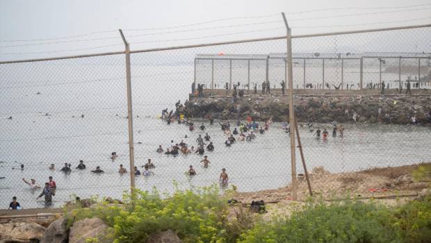 <i>Decenas de personas intentando cruzar la frontera por el espigón del Tarajal, en Ceuta, en imagen de archivo. / Marcos Moreno / Europa Press.</i>