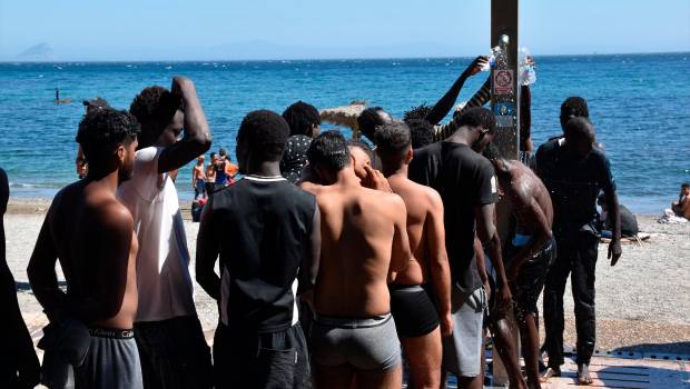 <i>Varias personas se asean en las duchas públicas, en la playa del Trampolín. / Europa Press. </i>
