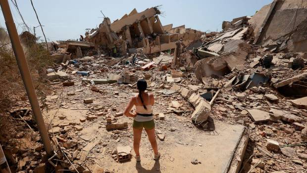 <i>Una mujer frente a varias casas derruidas por los terremotos. / Javier Campos / DPA.</i>