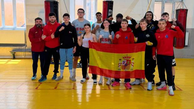 <i>Cristina Peinado y Manuel Bueno, primera y cuarto sujetando la bandera de España.</i>