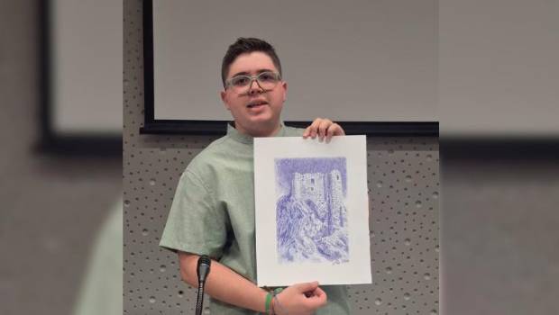 <i>En la imagen, Manuel David posa con el dibujo del Castillo de Huelma, portada de su libro y obra del artista local Paco Díaz. </i>