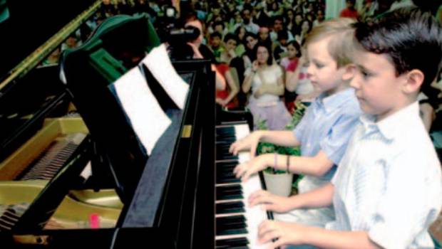 <i>Un grupo de niños de la escuela “Maestro Cebrián” interpreta una pieza con diferentes instrumentos. / Archivo Histórico de Diario JAÉN.</i>