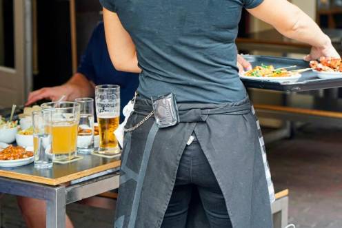 <i>Una camarera atiende a un cliente en un bar. </i>