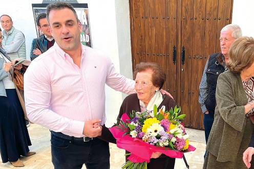 <i>Imagen del alcalde de Begíjar entregando un ramo de flores a María Catalina Soto, junto a vecinos y compañeros de gobierno. / A. Guzguti. / Diario JAÉN.</i>
