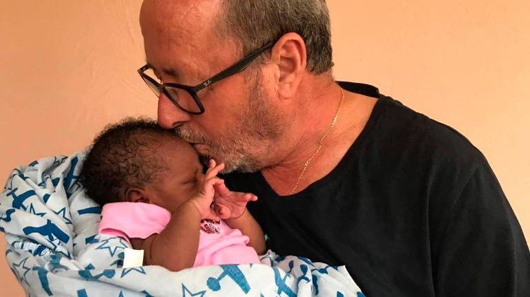 MARÍA DE LA PAZ. <i>Julio Millán, la semana pasada, con una niña que ha apadrinado Mensajeros de la Paz en la localidad de Fond Parisien, en Haití, donde viajó con una expedición jiennense.</i>