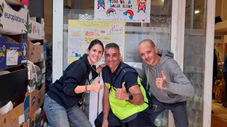 <i>Sergio junto a dos vecinos valencianos en la entrega de alimentos.</i>