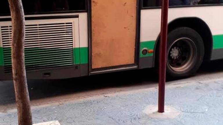 Un bus urbano circula con un cartón piedra en una puerta