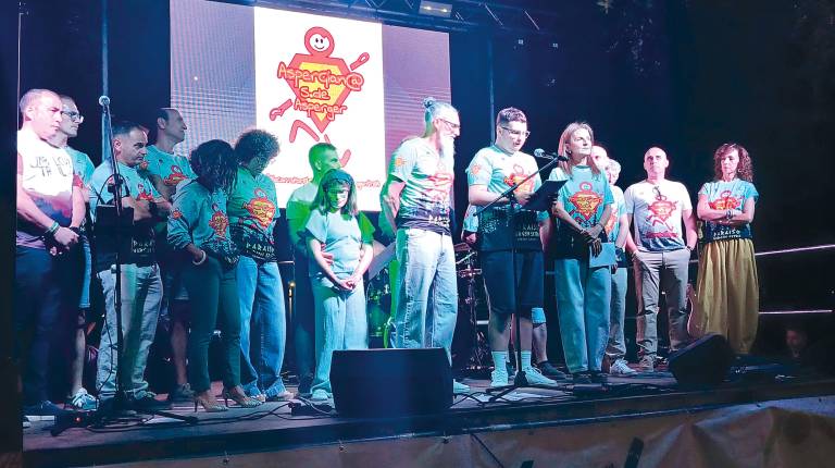 <i>Alejandro Castillo lee su pregón desde el escenario arropado por miembros del Club Aspergianos Jaén, durante el arranque de las fiestas en honor a San Cosme y San Damián en Jabalcuz. / Adrián Claudio Bonache / Diario JAÉN. </i>