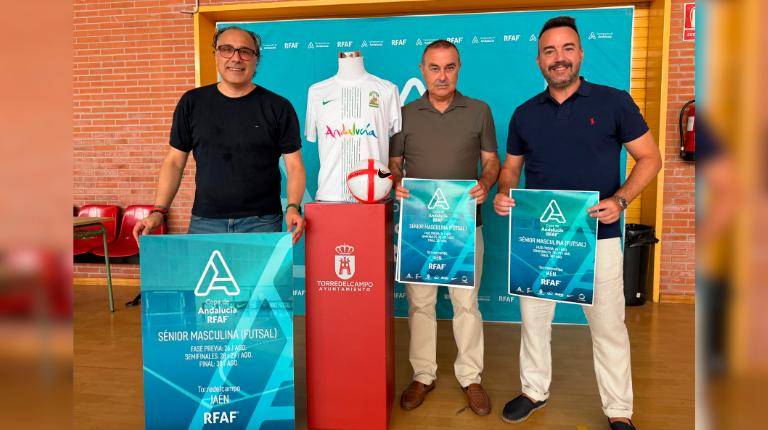 <i>Javier Chica, Rafael Hidalgo y Javier Mañas posan junto al cartel de la Copa de Andalucía de Fútbol Sala. / Ayuntamiento de Torredelcampo.</i>