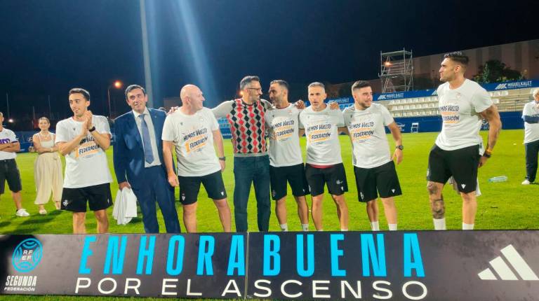 <i>Manuel Herrero, con su jersey talismán, posa con su cuadro técnico en el campo del Baleares. / Elsa Peña.</i>