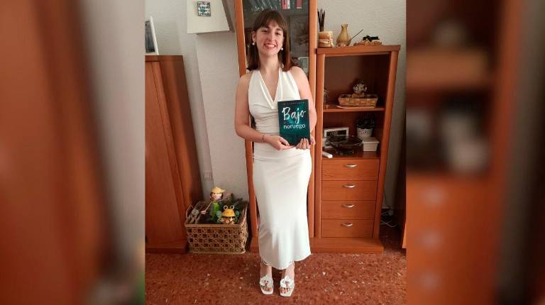 <i>La joven escritora Lucía Rodríguez posa con un ejemplar de “Bajo el cielo noruego”.</i>
