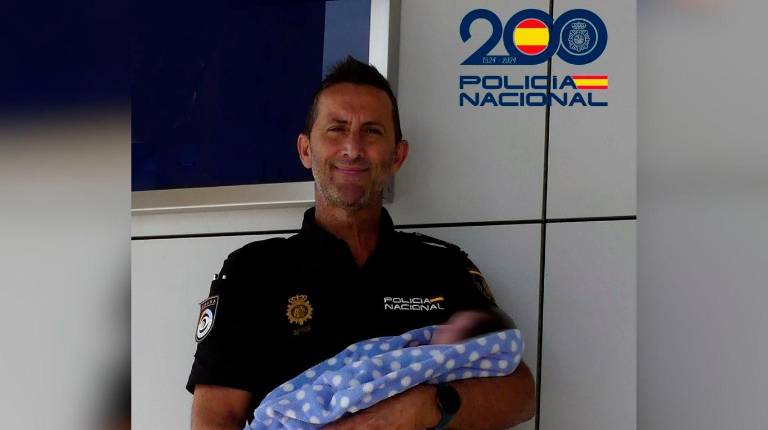 <i>Un agente de la Policía Nacional, con el bebé en los brazos. / Policía Nacional.</i>