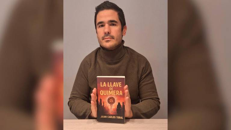 El escritor Juan Carlos Toral posa con su libro.