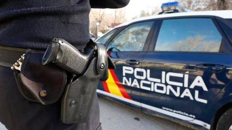 <i>Imagen de archivo de un agente y un coche de la Policía Nacional.</i>