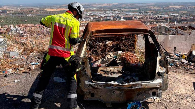 <i>Un bombero de Jaén trabaja en el despiece de un vehículo abandonado en las faldas del Castillo. / Ayuntamiento de Jaén. </i>