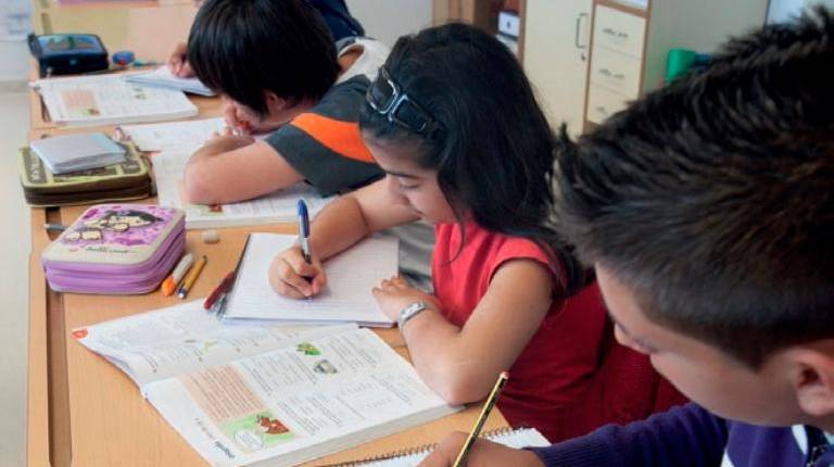 <i>Niños en el colegio con sus libros de texto. / Junta de Andalucía. </i>