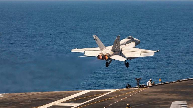 <i>Un caza F/A-18E Super Hornet de la Armada de los Estados Unidos asciende tras despegar de la cubierta de vuelo del portaaviones de la clase Ford USS Gerald R. Ford, en la operación Furia Épica. / Europa Press.</i>