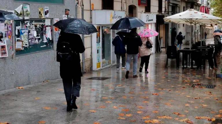 <i>Varias personas con paraguas en el Paseo de la Estación, en Jaén, esta mañana. / Jason Moyano / Diario JAÉN.</i>