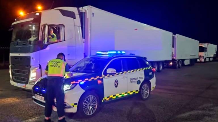 <i>Un agente de la Guardia Civil junto al camión que conducía el investigado. / Guardia Civil. </i>